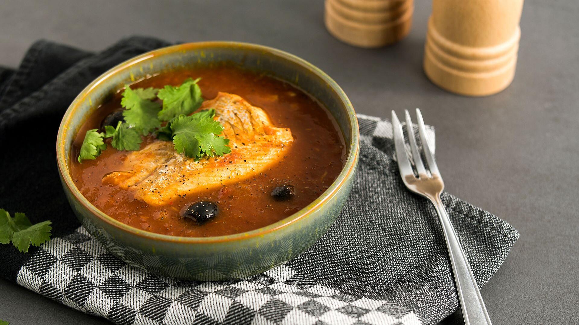 Eine Schüssel mit Kabeljau in Tomaten-Salzzitronen-Sugo und frischem Koriander