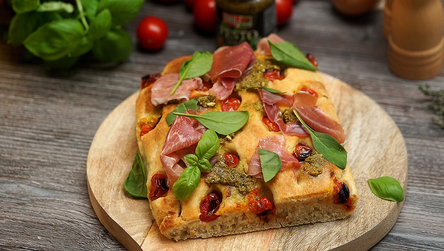 Focaccia mit grünem Pesto, Parmaschinken und Tomaten